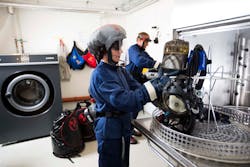 The room used for decontamination of gear should include a ventilation system that generates negative pressure to prevent contaminated air from escaping the room.