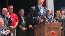 The Professional Fire Fighters of Massachusetts and Gov. Charlie Baker, pictured at lectern, worked on a bill to designate cancer as a work-related injury for state firefighters.