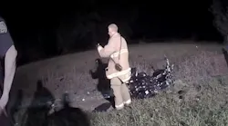 This screen grab from a Macomb County, MI, deputy sheriff's body cam shows firefighter Steven Hart examining a bottle of pills he picked up at the scene of a fatal crash on Aug. 21, 2018.