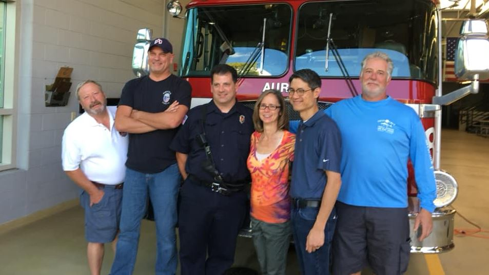Lisa Yee, second from right, poses with her husband Ted and four of the Aurora firefighters who rescued her after a serious car wreck left her with traumatic injuries in September 2008.