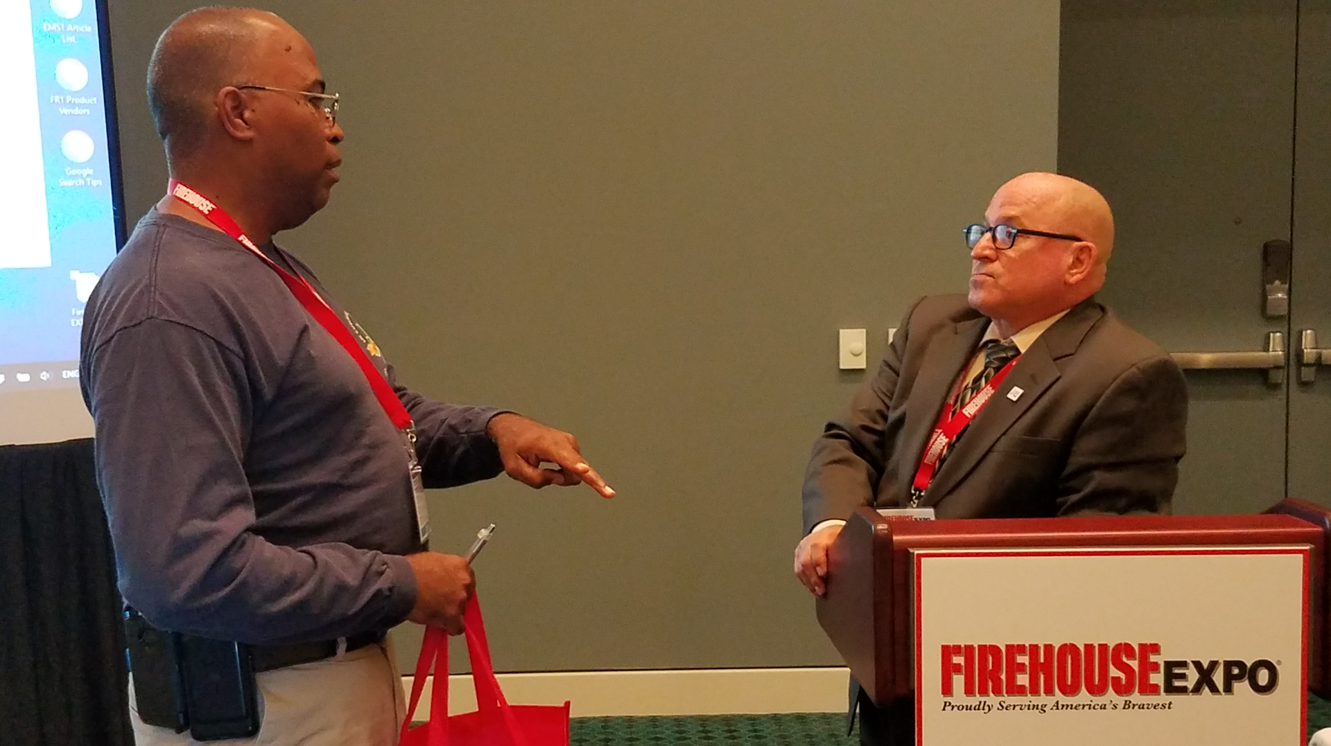 Retired Battalion Chief Robert Avsec, right, speaks with a Firehouse Expo attendee after his presentation on the identity crisis in the fire service.