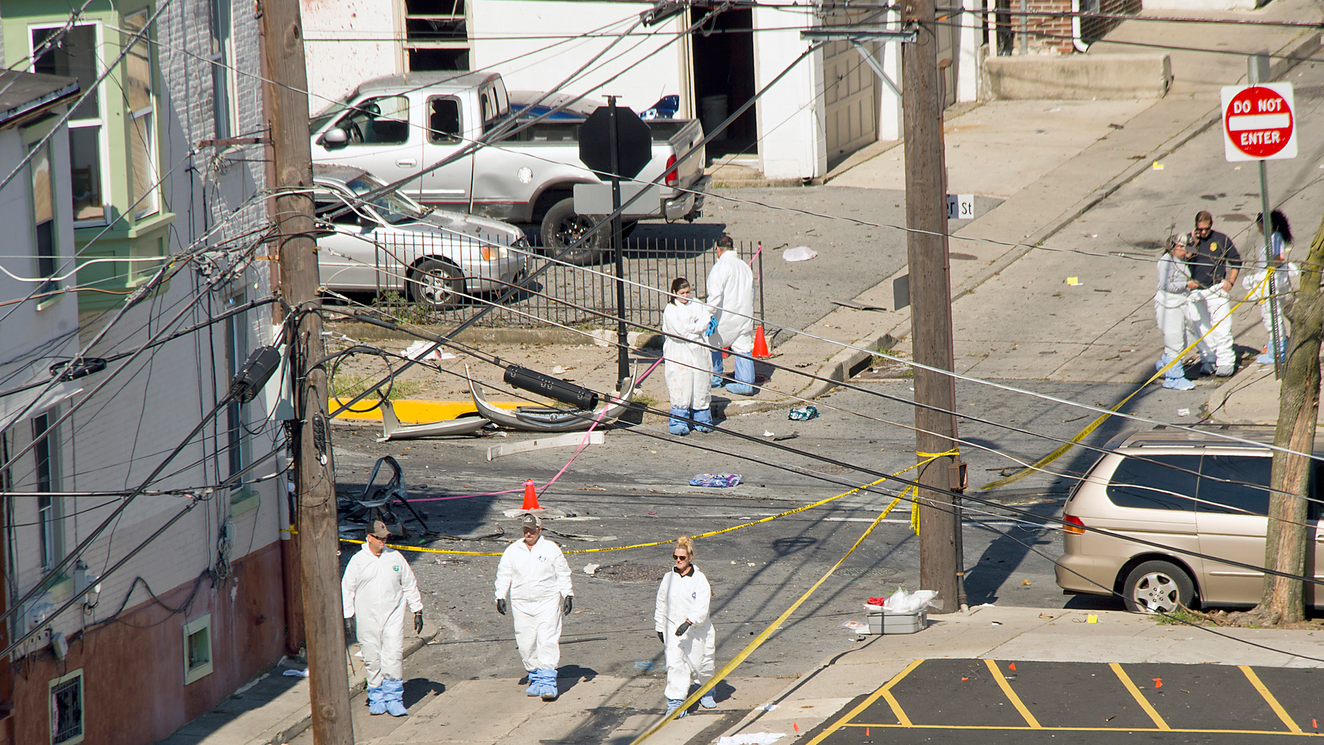 Police join members of the ATF and the FBI as they investigate a fiery car explosion that rocked an Allentown neighborhood on Saturday.