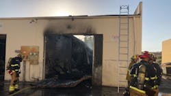Firefighters on scene after a two-alarm fire at an auto body shop in Westminster, CA, on Thursday, Oct. 11, 2018.