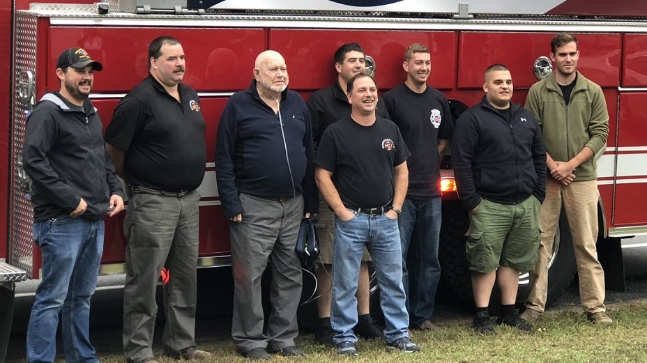 Eugene Carroll, third from left, poses with his fellow Morrisonville firefighters as they gather to celebrate his 90th birthday on Sunday, Oct. 7, 2018.