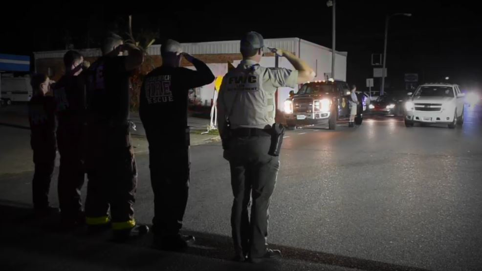 Gulf County first responders salute as a procession passes transporting the body of firefighter/paramedic Brad Price after he was killed while clearing debris in the wake of Hurricane Michael on Thursday, Oct. 18, 2018.
