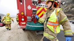 Cal Fire firefighters Trent Grinstead, background, left, and Anthony Lopez, right, arrive at a traffic collision on Interstate 15 near Escondido, CA. Cal Fire firefighters Trent Grinstead, background, left, and Anthony Lopez, right, arrive at a traffic collision on Interstate 15 near Escondido, CA.
