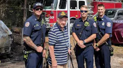 Marion County firefighters pose with an unidentified Air Force veteran whose American flag was burned during a vehicle fire at his home in Ocala, FL, on Monday, Oct. 1, 2018.