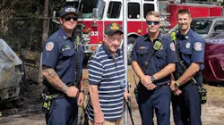 Marion County firefighters pose with an unidentified Air Force veteran whose American flag was burned during a vehicle fire at his home in Ocala, FL, on Monday, Oct. 1, 2018.