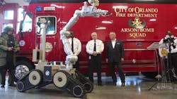 Orlando fire officials join Mayor Buddy Dyer, right, in unveiling a new bomb squad robot on Tuesday, Oct. 16, 2018.
