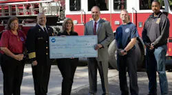 ADT’s Jay Robertson (center), who is also a volunteer firefighter, presents a $100,000 contribution to Heather Schafer, CEO of the NVFC.