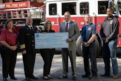 ADT’s Jay Robertson (center), who is also a volunteer firefighter, presents a $100,000 contribution to Heather Schafer, CEO of the NVFC. ADT’s Jay Robertson (center), who is also a volunteer firefighter, presents a $100,000 contribution to Heather Schafer, CEO of the NVFC.