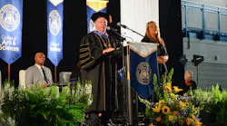 Columbia Southern University President Ken Styron speaks at the 2018 commencement on Oct. 19 as keynote speaker J.R. Martinez looks on seated behind him.