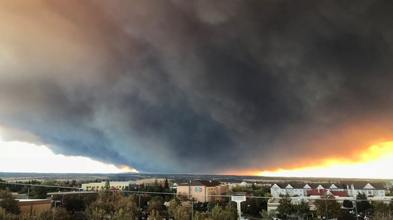 A massive plume of smoke hovers above the Camp Fire as seen from Chico, CA, in November 2018.