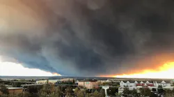 A massive plume of smoke hovers above the Camp Fire as seen from Chico, CA, in November 2018.