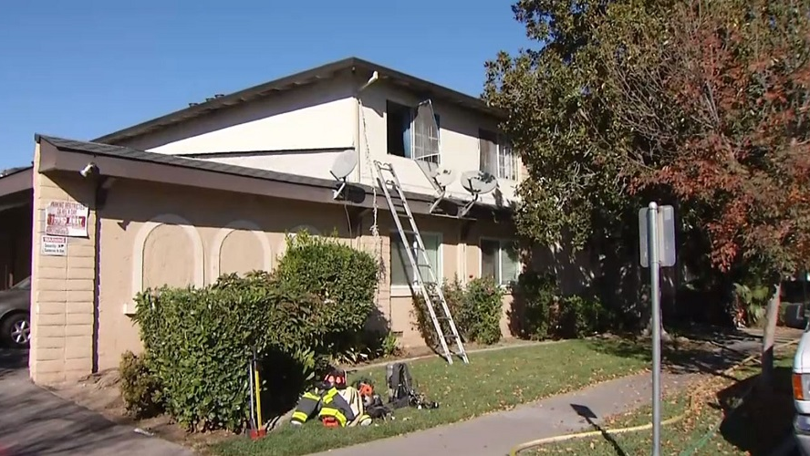 A ladder remains propped up against an apartment building after firefighters rescued two people who became trapped when a fire broke out in an adjacent unit on Wednesday, Nov, 7, 2018.