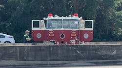 A vintage fire engine rests against a dividing wall on a Biloxi, MS, roadway after a wreck on Monday, Nov. 29, 2018.