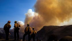 Firefighters watch a plume of smoke rise from the Woolsey fire near the Chatsworth reservoir on Nov. 11, 2018, in Los Angeles. Firefighters watch a plume of smoke rise from the Woolsey fire near the Chatsworth reservoir on Nov. 11, 2018, in Los Angeles.