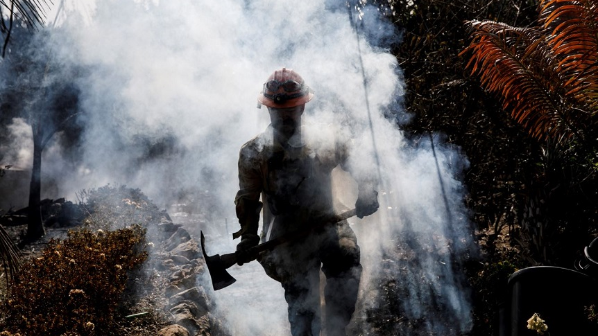 Battalion 13 Capt. Victor Correa with the Los Angeles County Fire Department helps put out hot spots on the Woolsey Fire in Malibu, CA, on Nov. 12, 2018.