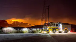 Ventura County, CA, Fire Department Engine 43 stands watch in Woolsey Canyon during the early stages of the Woolsey Fire. The streak of light at center-left in the background is a helicopter making a water drop.