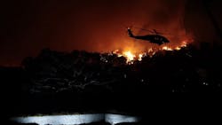 A helicopter battles the Woolsey Fire in the hills above Pepperdine University in Malibu, CA, on Friday, Nov. 9, 2018.