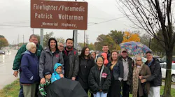 The family of fallen Hamilton, OH, firefighter Patrick Wolterman poses in front of a sign dedicating a stretch of Route 4 in his honor on Thursday, Nov. 1, 2018.
