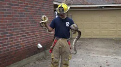 A Caney Creek firefighter holds just a few of the over 100 snakes crews removed from a Conroe, TX, home after a fire on Saturday, Dec. 8, 2018.