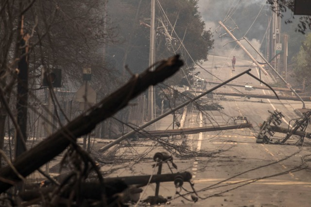Power poles and lines block a street at Brookdale and Aaron Dr. in Hidden Valley, CA, where most of the homes were destroyed by fire in Santa Rosa on Oct. 9, 2017.