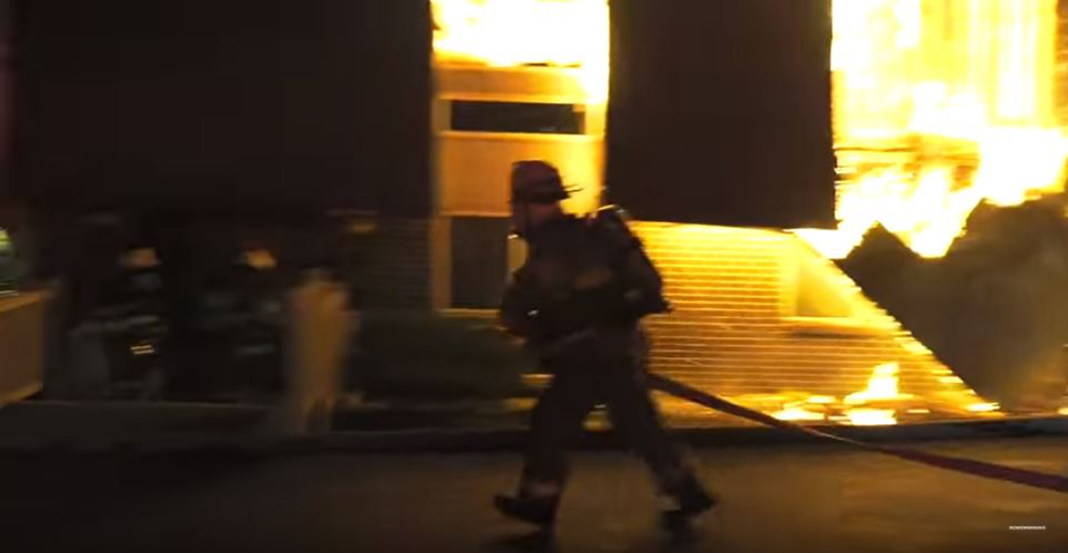 A firefighter deploys a hoseline at the deadly Whitehall Twp. apartment building fire.