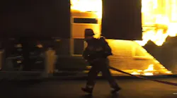 A firefighter deploys a hoseline at the deadly Whitehall Twp. apartment building fire.