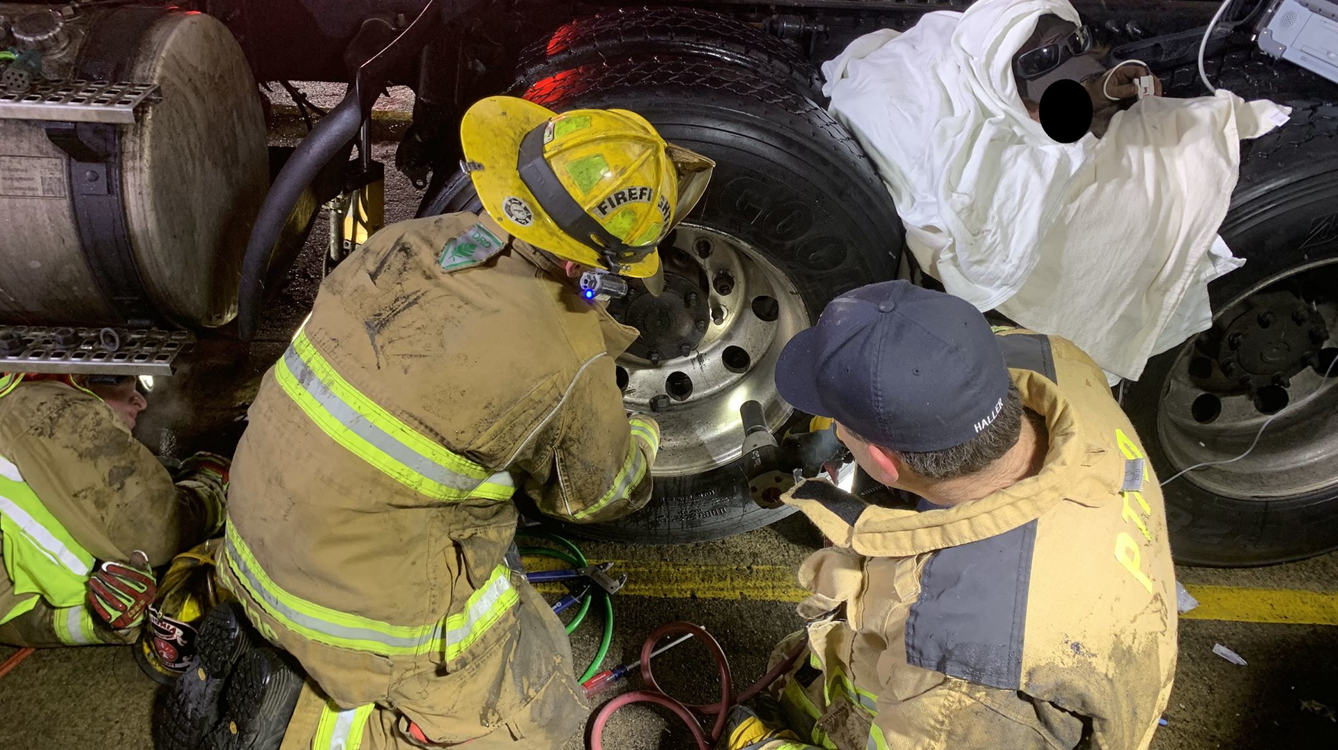 Livonia firefighters rescued a person trapped between two tractor-trailer tires Thursday night in Plymouth Township, MI.