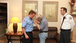 New Orange County Fire Rescue firefighter Greg Ferone receives his ceremonial pin from his father, Ed. New Orange County Fire Rescue firefighter Greg Ferone receives his ceremonial pin from his father, Ed.