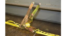 After tightening a ratchet tie-down unit as fully as necessary by hand, rescuers should close the handle, so it latches over the sprocket slide bar and secures the mandrel core in position.
