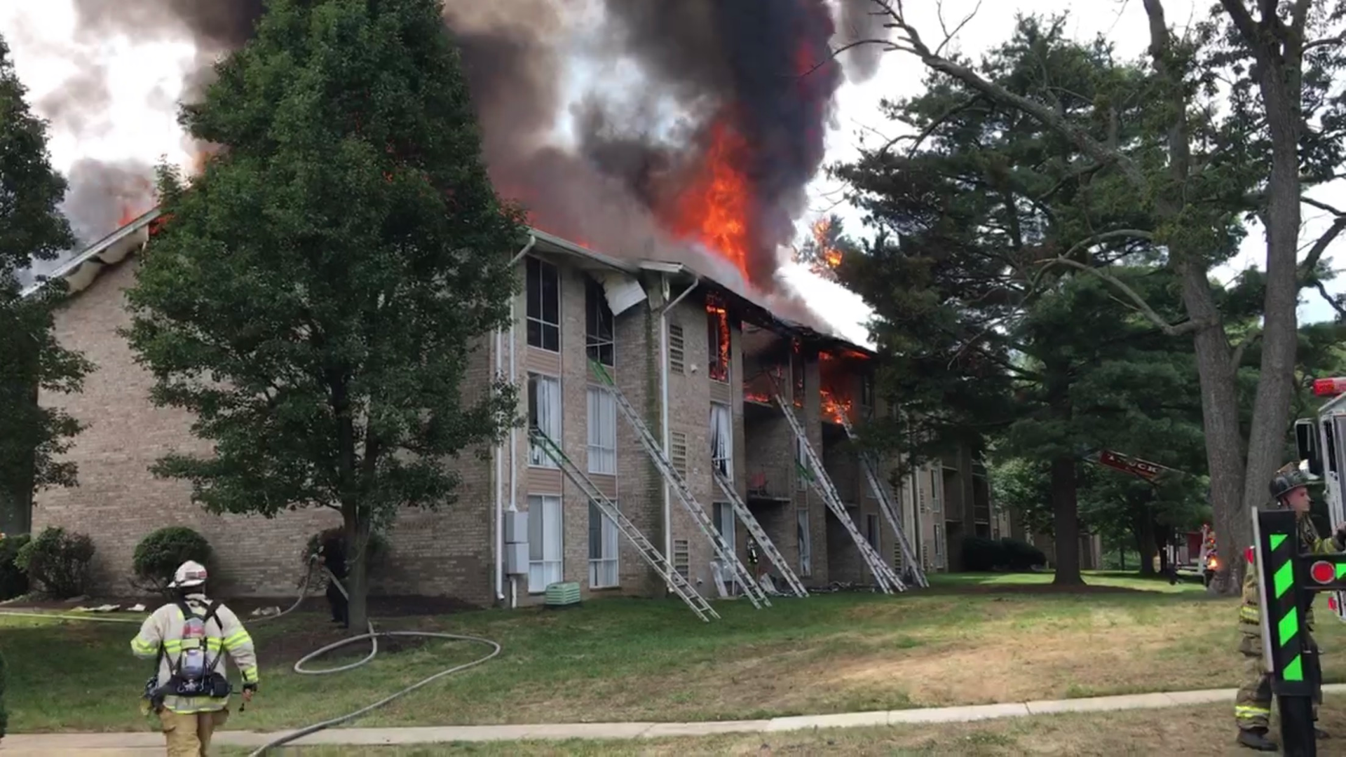 The rear side of the building shows fire from and near the apartment of origin. The trench cut was in progress at this time.
