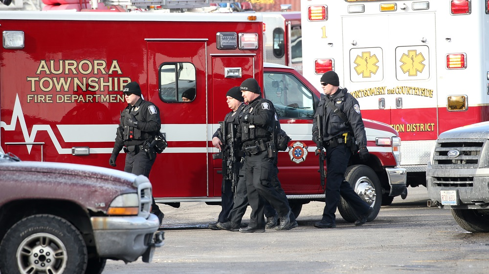 Police officers armed with rifles respond to a shooting Friday afternoon at a manufacturing plant in Aurora, a suburb west of Chicago