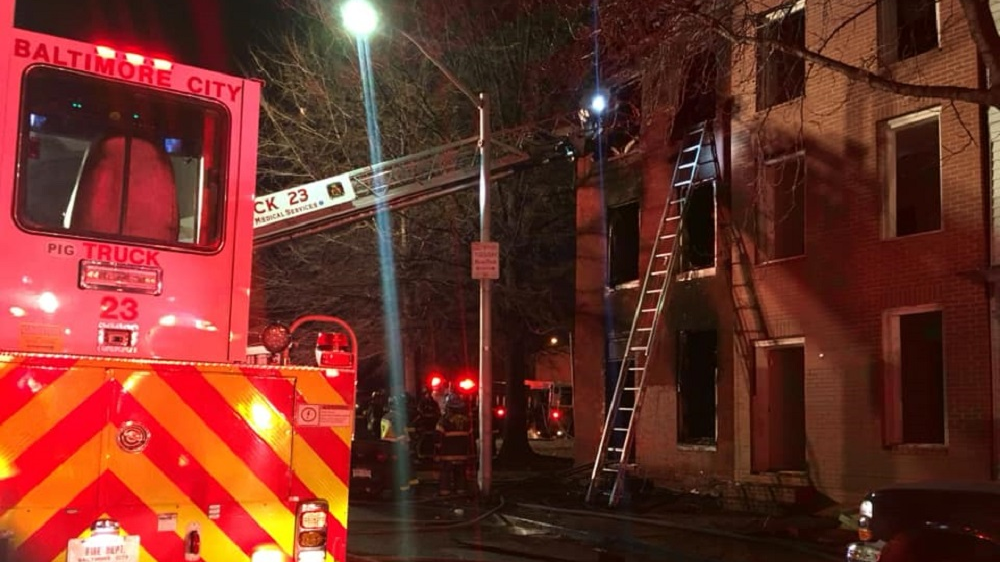 A Baltimore City firefighter escaped injury Saturday after falling through the floor while battling a fire at a three-story vacant home.