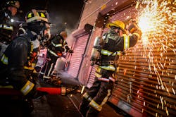Understanding that cutting and removing roll-down gates creates additional ventilation points that will cause the fire to expand, firefighters positioned a hoseline at the roll-down before the gate was opened. Understanding that cutting and removing roll-down gates creates additional ventilation points that will cause the fire to expand, firefighters positioned a hoseline at the roll-down before the gate was opened.