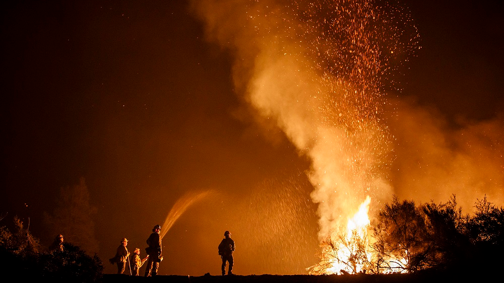 California firefighters monitor an Aug. 7 burn operation on top of a ridge near the town of Ladoga.