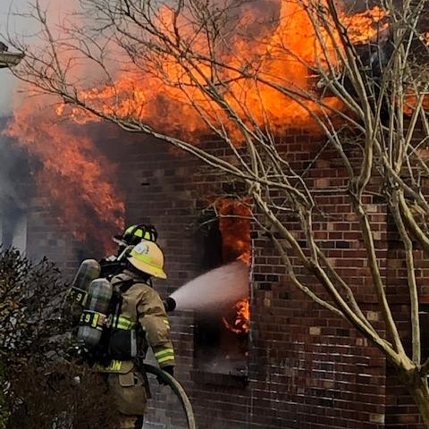 Suffolk crews rescued a firefighter trapped under rubble from a wall that collapsed on her while battling a rural home blaze Monday morning.