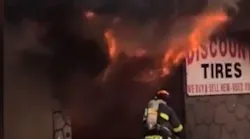 Dozens of firefighters tackled a 'tenacious tire store blaze' in Hallandale Beach on Friday night.