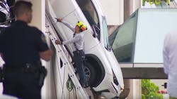 Firefighters rescued a driver from an SUV that was dangling from a parking garage Thursday in Miami Springs.