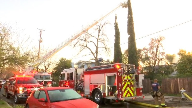 A Fresno firefighter was hit by debris while battling a blaze at at two-story building that killed a person.