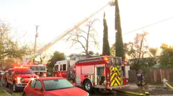 A Fresno firefighter was hit by debris while battling a blaze at at two-story building that killed a person.