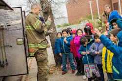 After receiving their coats, the children go outside to tour the fire trucks. After receiving their coats, the children go outside to tour the fire trucks.
