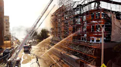 Los Angeles firefighters pour water on hot spots after a massive fire at an apartment complex construction site on Dec. 8, 2014.
