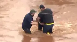A bystander pulled a woman from fast-moving floodwaters in Oklahoma City, OK, on Tuesday.