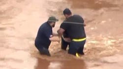 A bystander pulled a woman from fast-moving floodwaters in Oklahoma City, OK, on Tuesday.