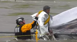 A Houston firefighter helps rescue a man Monday who was caught in swift-moving waters under a bridge and initially refused help from crews.
