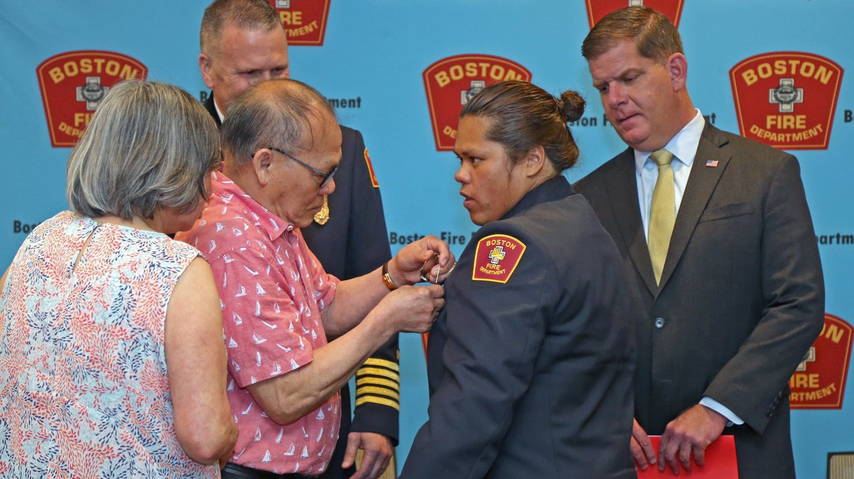 Na Ho, 76, pinned a badge on the blazer of his daughter, May Ho, who became the Boston Fire Department's first female Asian-American firefighter Thursday.