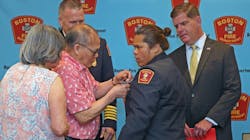 Na Ho, 76, pinned a badge on the blazer of his daughter, May Ho, who became the Boston Fire Department&apos;s first female Asian-American firefighter Thursday.