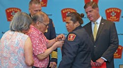 Na Ho, 76, pinned a badge on the blazer of his daughter, May Ho, who became the Boston Fire Department's first female Asian-American firefighter Thursday. Na Ho, 76, pinned a badge on the blazer of his daughter, May Ho, who became the Boston Fire Department's first female Asian-American firefighter Thursday.